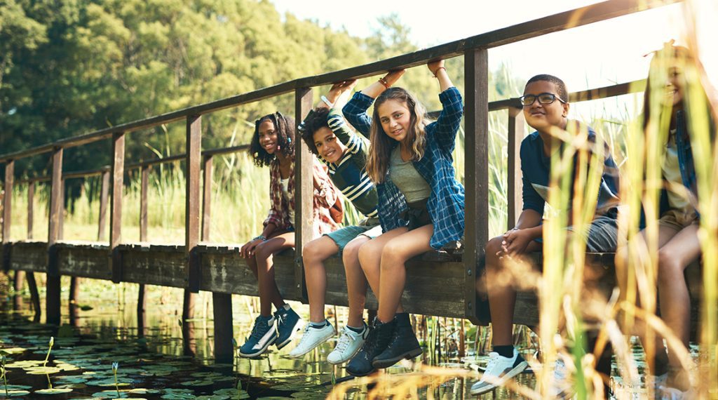 Teens in summer on a bridge - vacation may lead to a summer slide learning loss