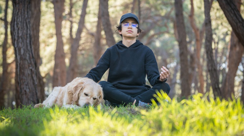 Teen boy meditating to build emotional intelligence in adolescence