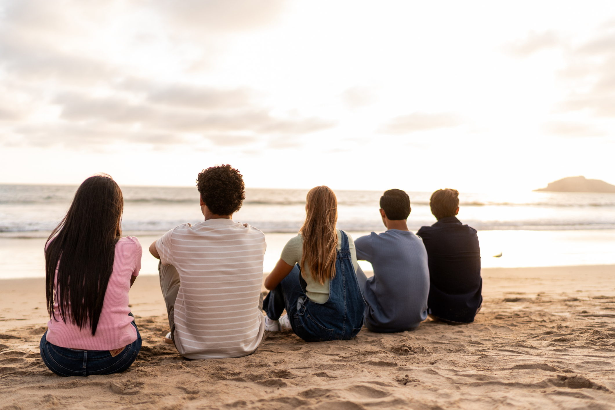 Teenage friends looking at view on the beach